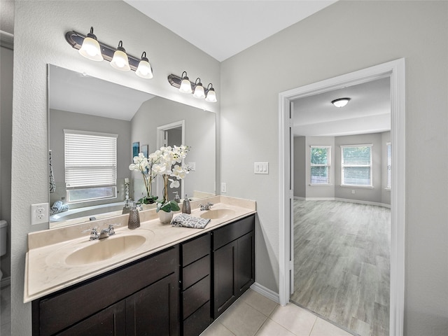 full bath featuring double vanity, baseboards, a sink, and tile patterned floors