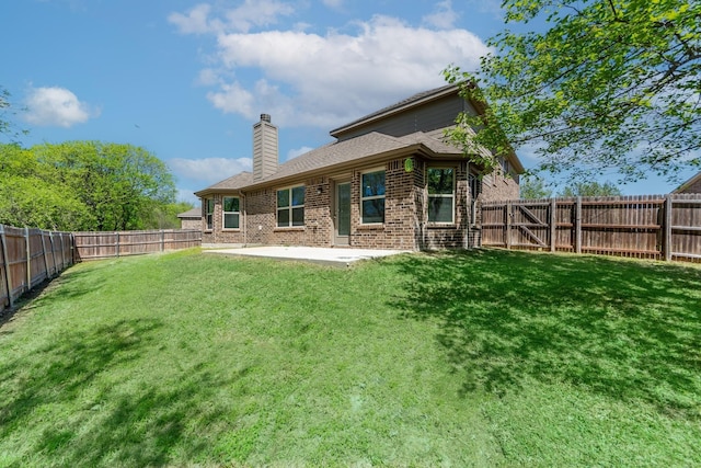 back of house featuring brick siding, a patio, a chimney, a lawn, and a fenced backyard