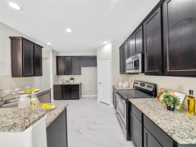 kitchen with marble finish floor, stainless steel appliances, light stone counters, and recessed lighting