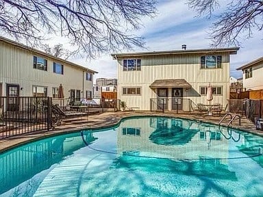 community pool featuring a patio area and fence