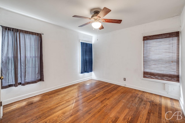 empty room with a ceiling fan, baseboards, and wood finished floors