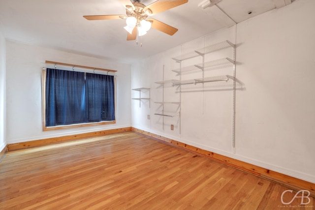 empty room featuring baseboards, a ceiling fan, and wood finished floors