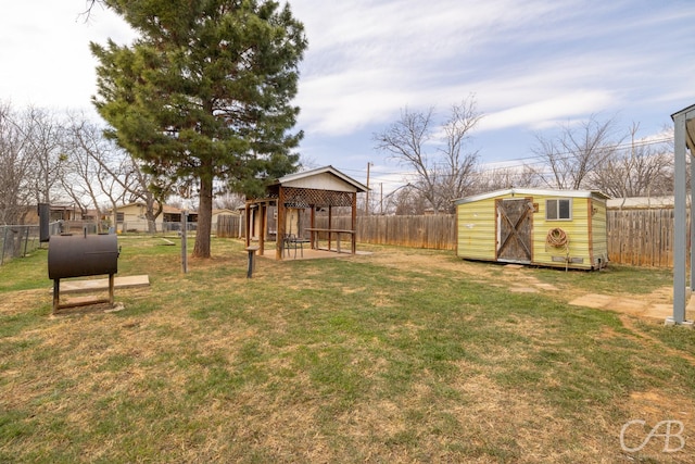 view of yard featuring an outbuilding, a storage unit, and a fenced backyard