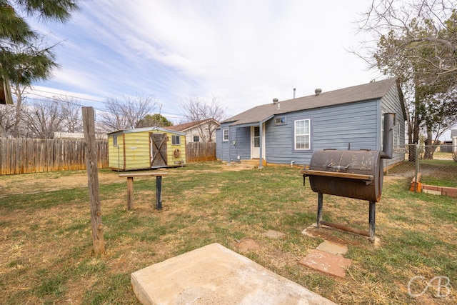 view of yard featuring entry steps, a storage shed, a fenced backyard, and an outdoor structure