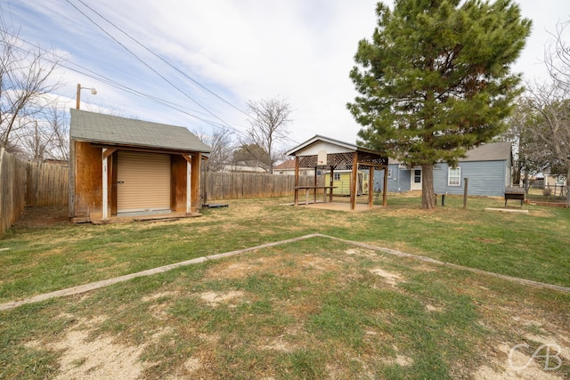 view of yard with a storage shed, a fenced backyard, and an outdoor structure