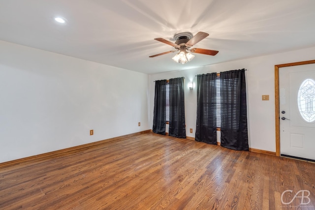 foyer featuring ceiling fan, baseboards, and wood finished floors