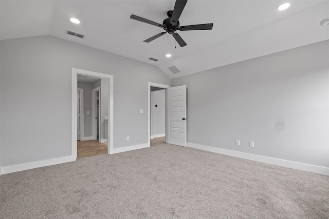 unfurnished bedroom with carpet floors, baseboards, visible vents, and vaulted ceiling