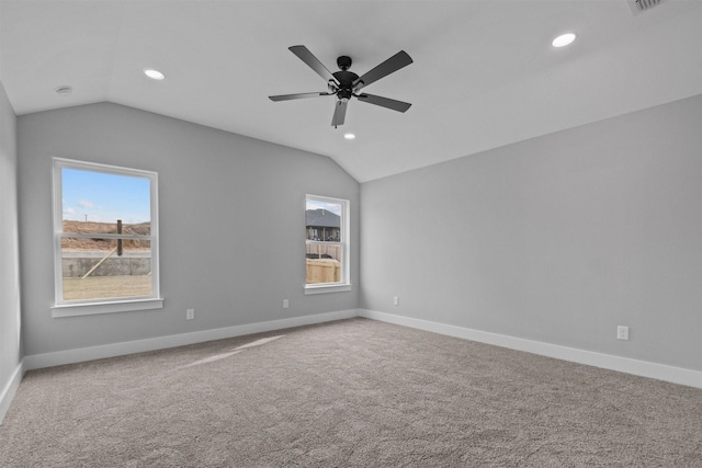 unfurnished room featuring vaulted ceiling, baseboards, and a healthy amount of sunlight