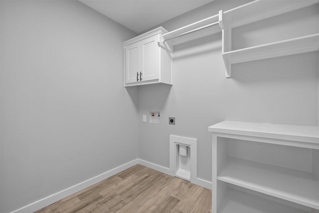 washroom with cabinet space, baseboards, hookup for a washing machine, light wood-type flooring, and electric dryer hookup