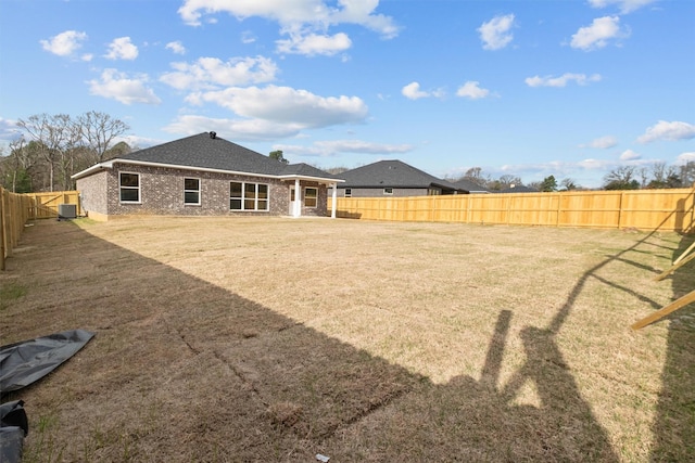 rear view of house featuring a lawn, a fenced backyard, and central air condition unit