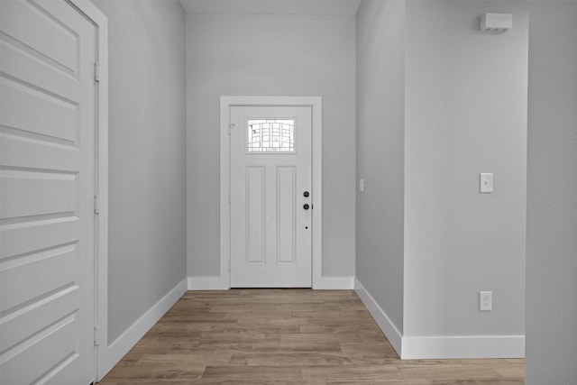 foyer entrance featuring light wood finished floors and baseboards