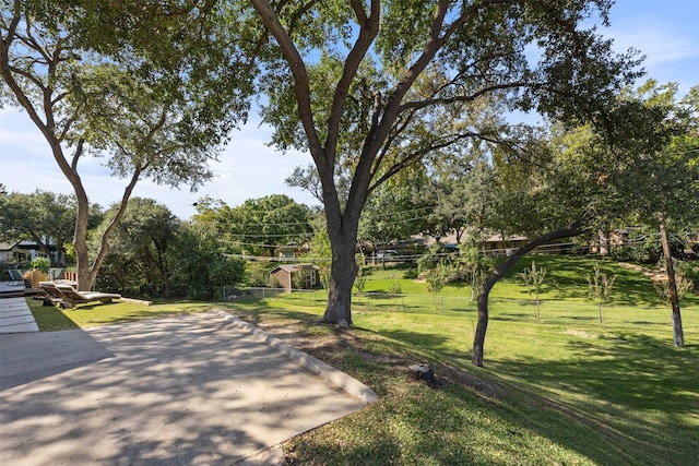 view of home's community with a yard and fence