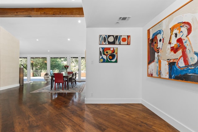 dining area featuring baseboards, beam ceiling, visible vents, and wood finished floors