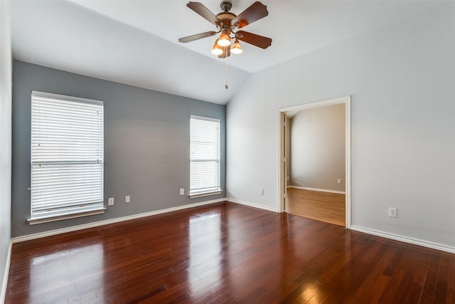 empty room featuring a ceiling fan, dark wood-style flooring, vaulted ceiling, and baseboards