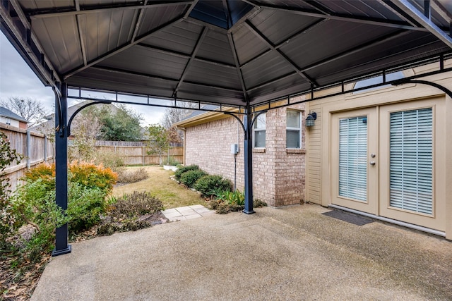 view of patio featuring a gazebo, french doors, and fence