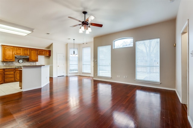 unfurnished living room featuring baseboards, a ceiling fan, and wood finished floors