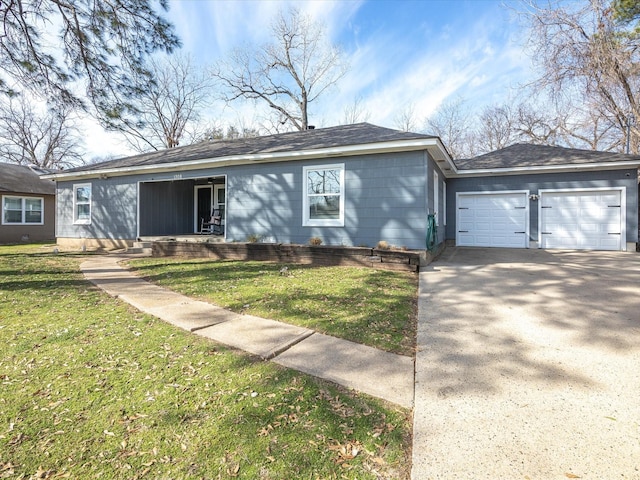 ranch-style home featuring driveway, an attached garage, and a front yard