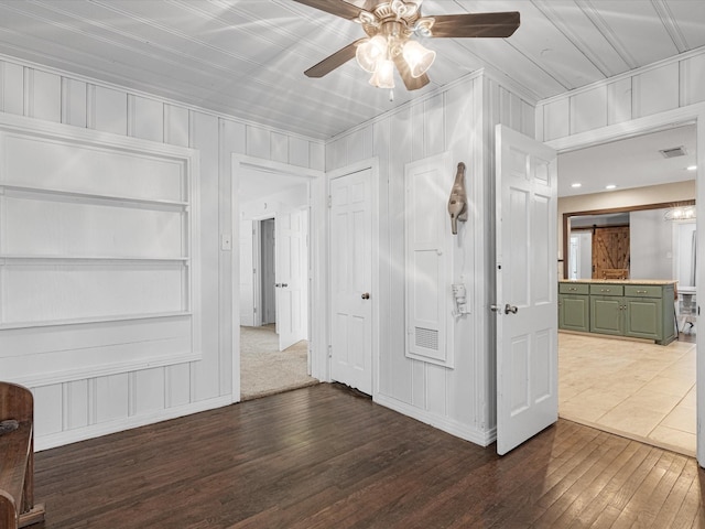 unfurnished room featuring dark wood-style floors, visible vents, and a ceiling fan