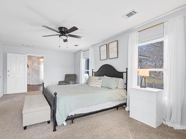 bedroom with carpet flooring, visible vents, and a ceiling fan