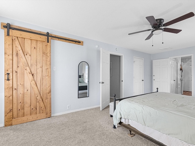 unfurnished bedroom featuring a ceiling fan, carpet, baseboards, and a barn door