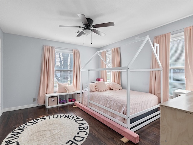 bedroom with a ceiling fan, dark wood finished floors, and baseboards