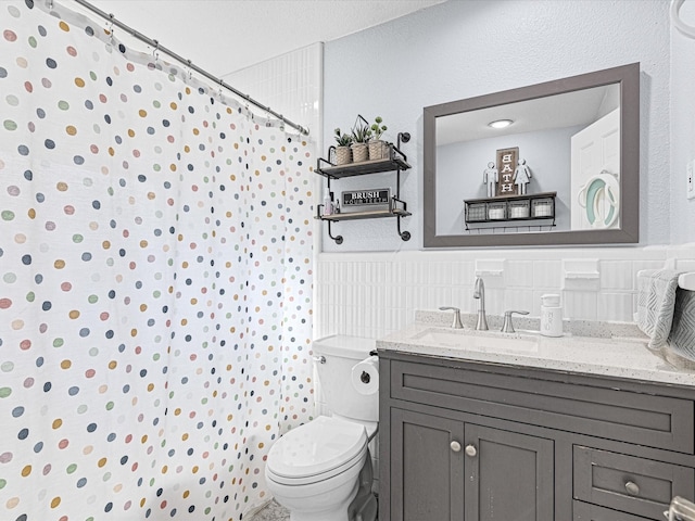 bathroom featuring a shower with curtain, wainscoting, vanity, and toilet