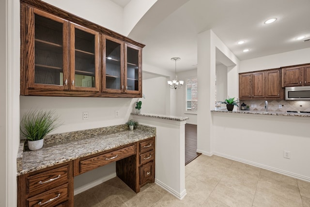 6413 Valley View Dr, Mckinney, TX 75071 - kitchen with glass insert cabinets, recessed lighting, stainless steel microwave, light stone counters, and a notable chandelier