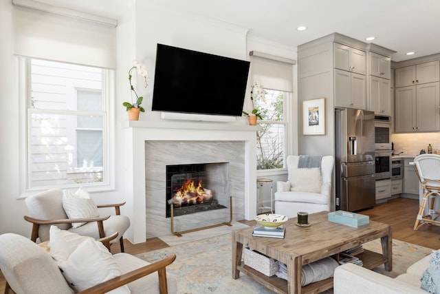 living room with light wood finished floors, a fireplace, and recessed lighting