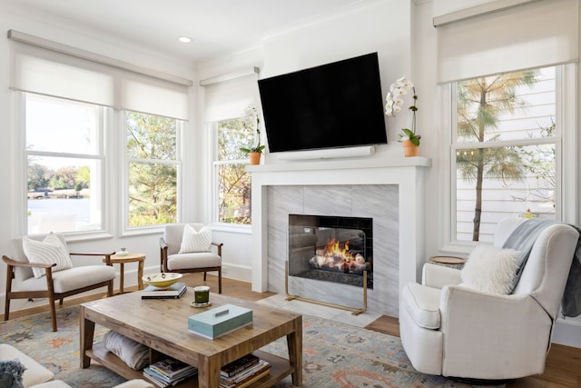 living area with recessed lighting, baseboards, crown molding, and a tile fireplace