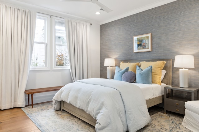 bedroom with baseboards, light wood-style floors, multiple windows, and wallpapered walls