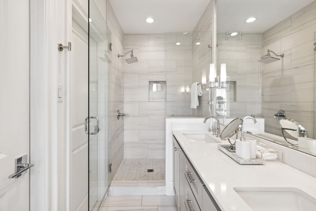 bathroom with recessed lighting, a sink, a shower stall, and double vanity