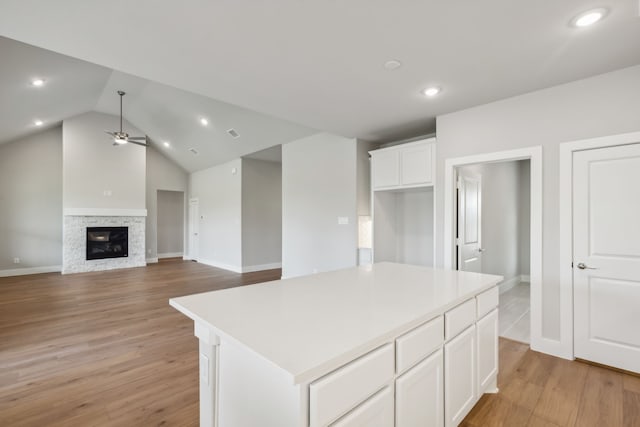 kitchen with open floor plan, light countertops, a fireplace, and a center island