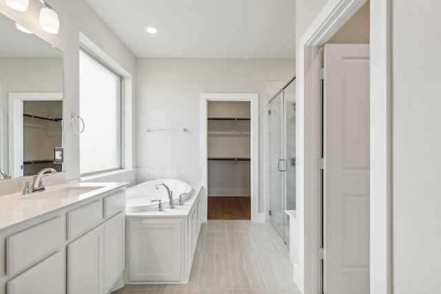 full bathroom with a stall shower, a garden tub, vanity, and tile patterned floors