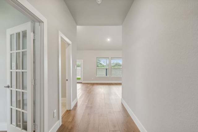 hallway with light wood-type flooring and baseboards