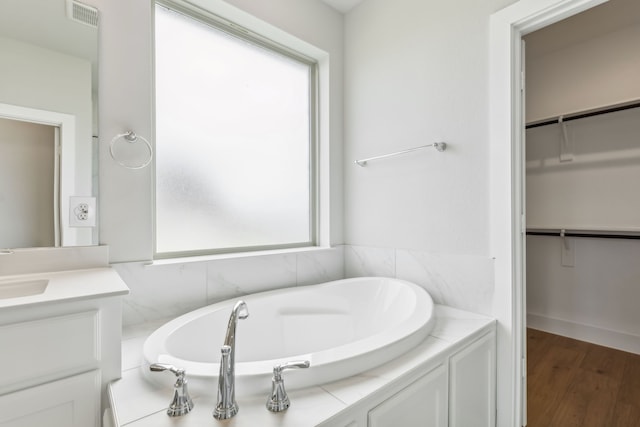 bathroom with visible vents, plenty of natural light, a spacious closet, and vanity