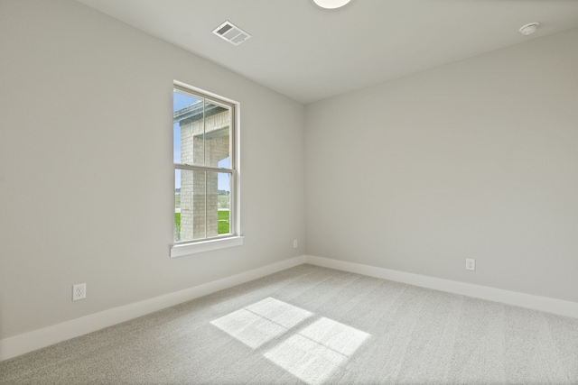 unfurnished room with baseboards, visible vents, and light colored carpet