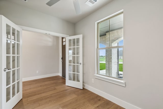 unfurnished room featuring baseboards, french doors, visible vents, and light wood-style floors