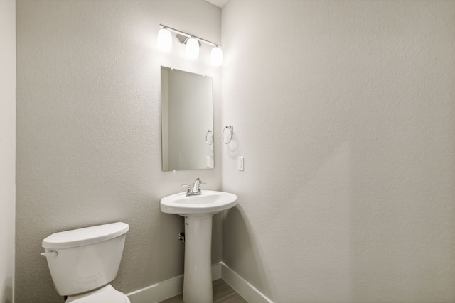 bathroom featuring toilet and baseboards