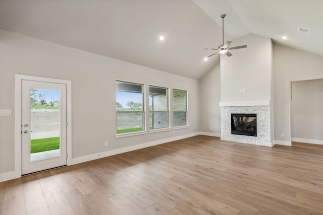 unfurnished living room featuring a healthy amount of sunlight, light wood-type flooring, visible vents, and a multi sided fireplace