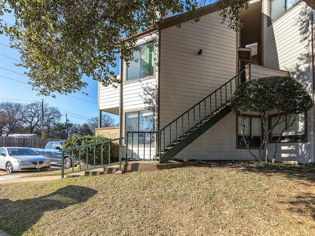 view of home's exterior featuring a yard and stairway