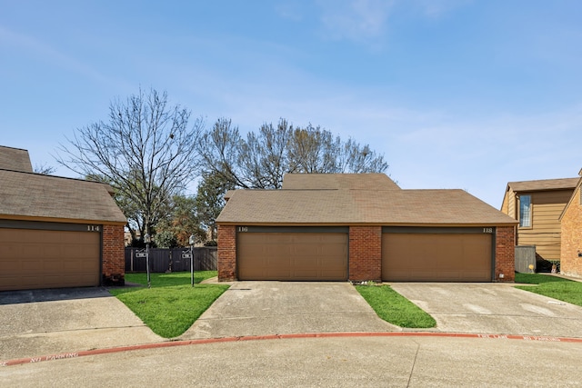 view of front facade featuring a garage, a front lawn, fence, and brick siding