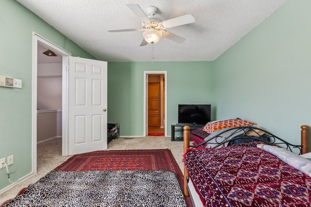 bedroom with light carpet, a textured ceiling, a ceiling fan, and baseboards