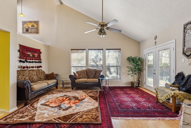 living room with french doors, a ceiling fan, a textured ceiling, wood finished floors, and baseboards