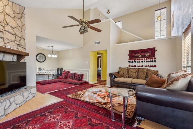 living room featuring visible vents, lofted ceiling, ceiling fan, wood finished floors, and a fireplace