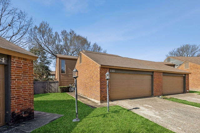 view of side of home with fence, an outdoor structure, a lawn, and brick siding