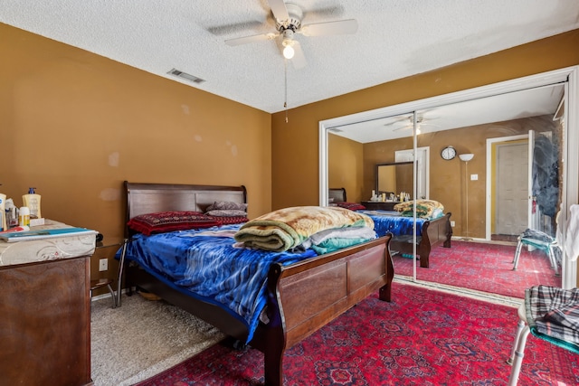 bedroom featuring carpet, visible vents, a ceiling fan, a textured ceiling, and baseboards