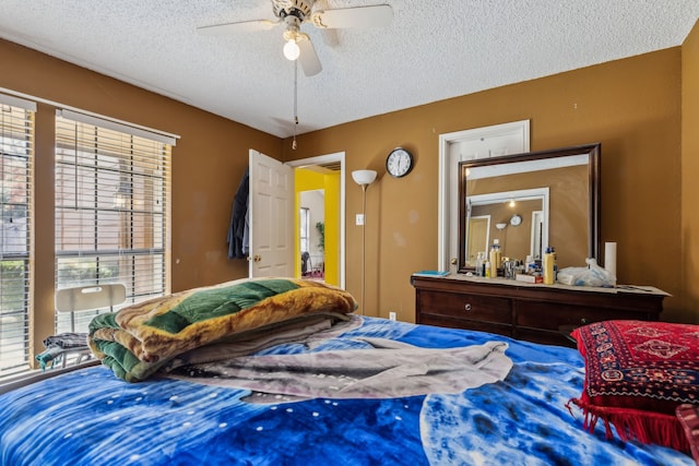 bedroom with ceiling fan and a textured ceiling