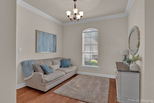 living area featuring light wood-type flooring, an inviting chandelier, baseboards, and ornamental molding