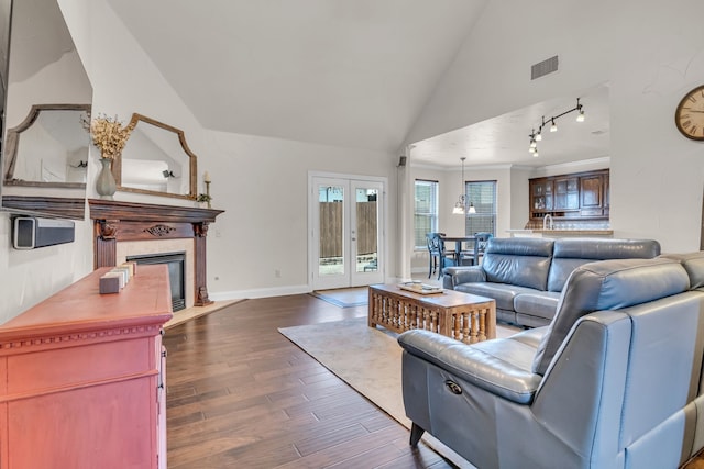 living area with visible vents, a tile fireplace, dark wood-style flooring, french doors, and track lighting