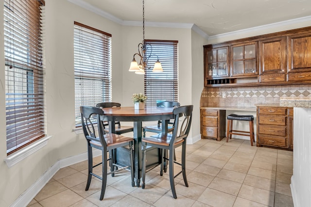 dining room with ornamental molding, light tile patterned flooring, and baseboards